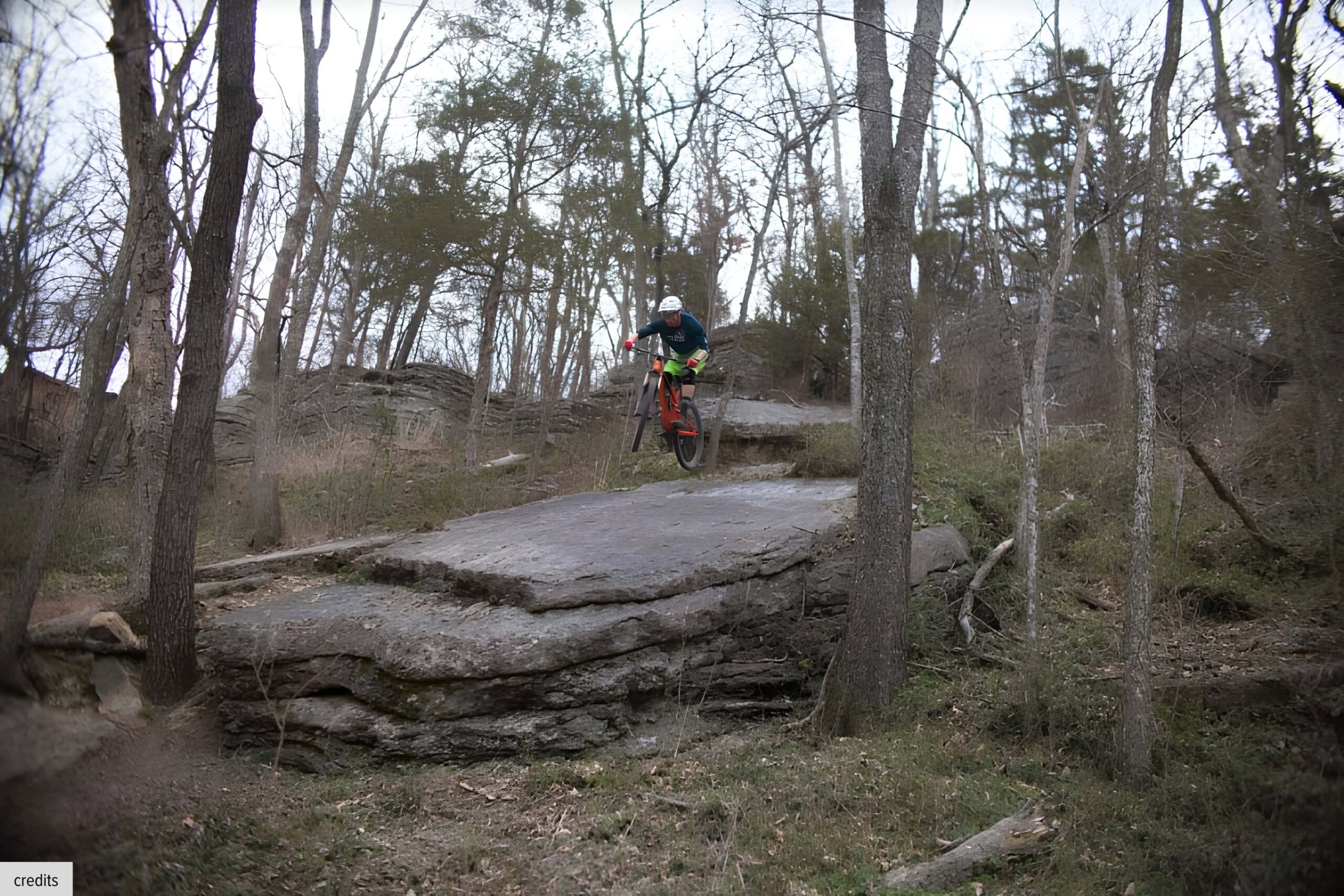 Mountain biker riding a scenic trail through Blowing Springs Park in Cave Springs, Arkansas.