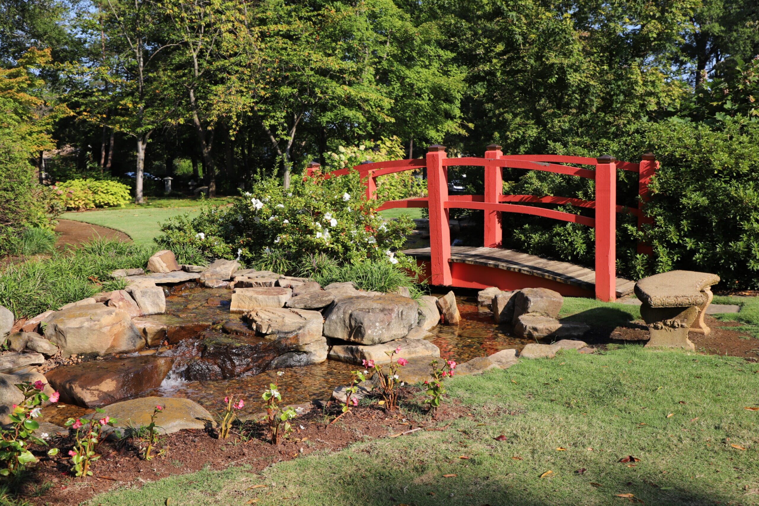 Red bridge over a stream in Decatur City Park.