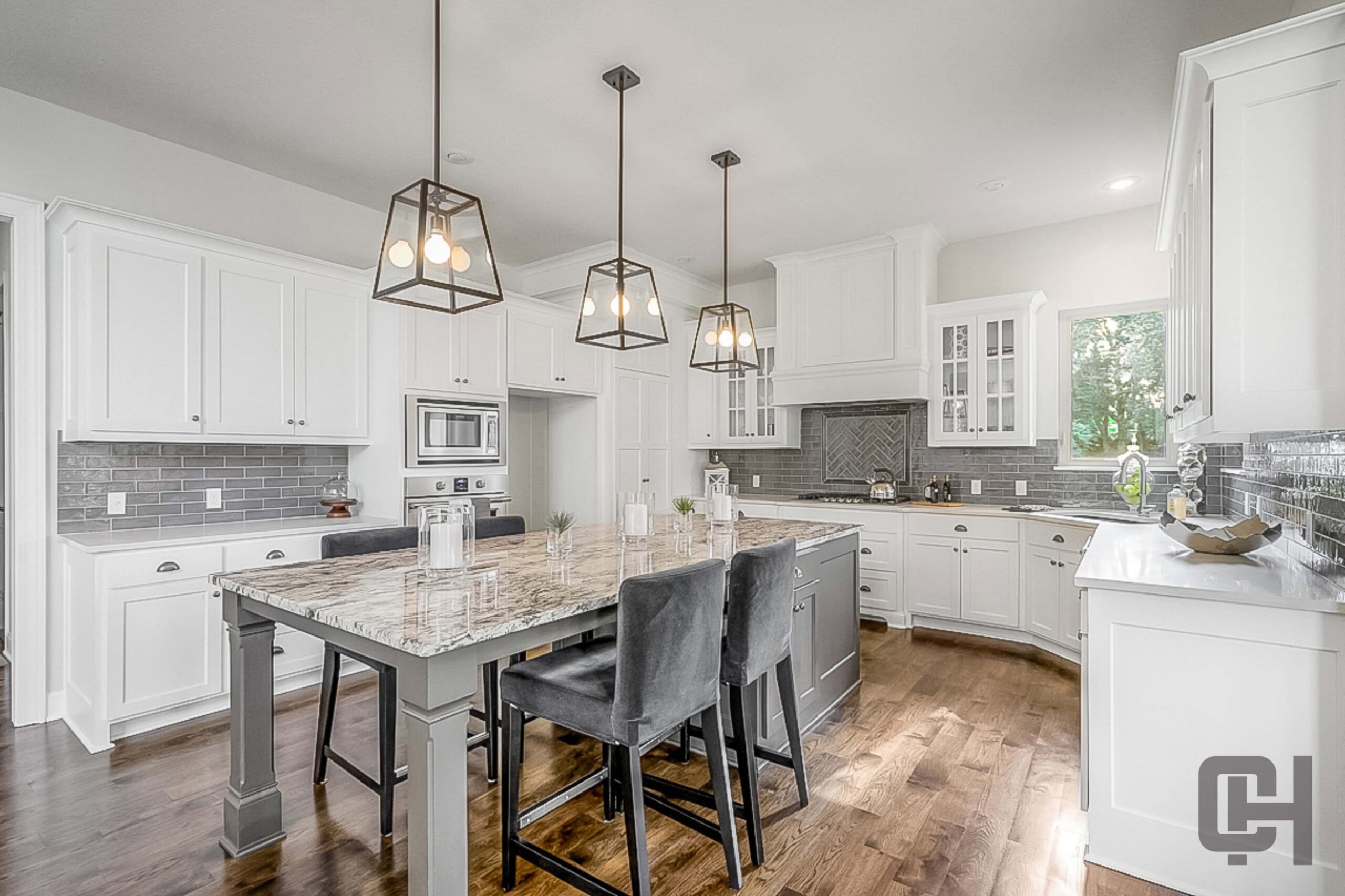 Bright white kitchen with a large island and modern finishes in the Lago floor plan.